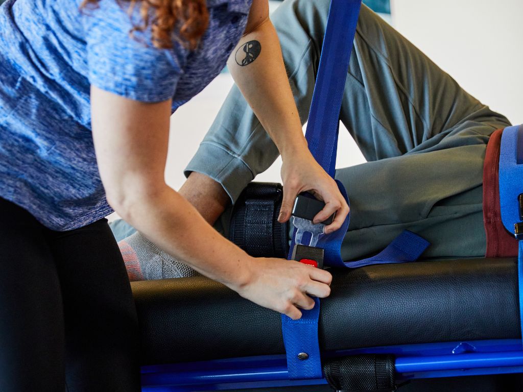 Practitioner adjusting straps on a client at a Stretch Zone studio